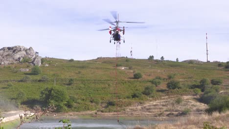 Während-Der-Waldbrände-Schwebt-Ein-Kamov-Ka-32T-Hubschrauber-über-Einem-Teich,-Um-Den-Wassersack-Zu-Füllen