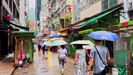 Daytime-Slow-Motion-of-People-with-Umbrellas-on-Tai-Yuen-Street-in-Hong-Kong-During-Rain