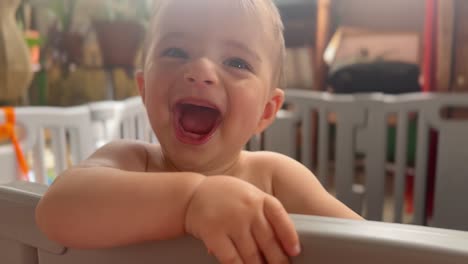True-laughter-baby-enjoying-himself-fun-charismatic-Caucasian-toddler-in-a-playpen