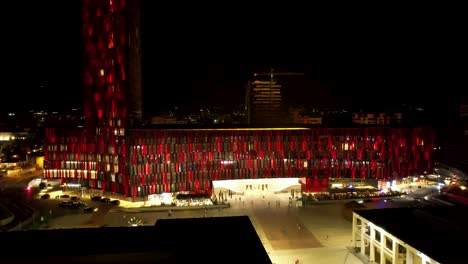Air-Albania-Arena-stadium-with-colorful-façade-at-night-in-Tirana,-beautiful-hotel-and-paved-square-for-football-fans-and-music-concerts