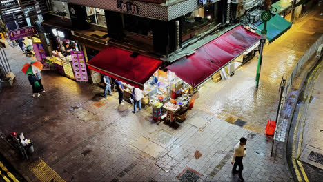 Puesto-De-Comida-En-La-Esquina-De-La-Noche-En-Hong-Kong-Con-Gente-Comprando-Y-Comiendo-Comida-Callejera
