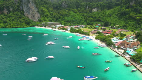 Boats-docked-near-tropical-island-of-Phi-Phi,-aerial-drone-view