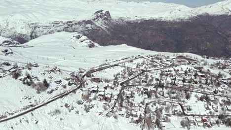 Aerial-view-flying-over-snow-covered-Farellones-ski-resort-village-neighbourhood-in-the-Andes-mountains,-Santiago,-Chile