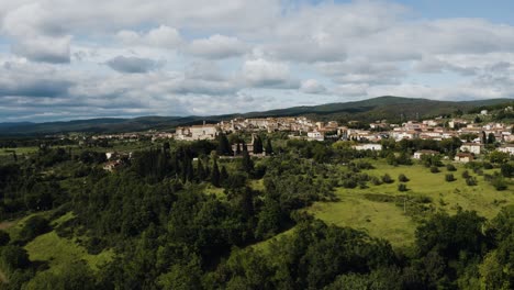 Wide-drone-shot-pulling-away-from-the-quaint-town-of-Rapolano-Terme-nestled-in-Italy's-countryside