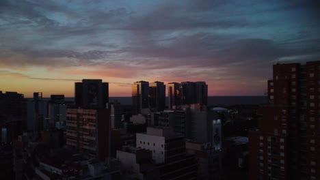 Drone-flies-over-Buenos-Aires-city,-cold-sunset-sky