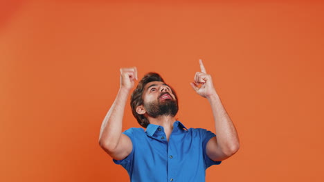 Young-man-showing-thumbs-up-and-pointing-at-left-on-blank-space,-place-for-your-advertisement-logo