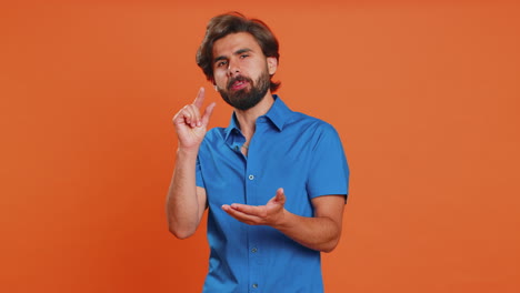 Man-showing-a-little-bit-gesture-with-sceptic-smile-showing-minimum-sign-measuring-small-size