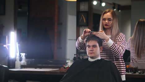 Men's-hair-salon,-the-girl-makes-a-haircut-scissors-in-a-brutal-interior.