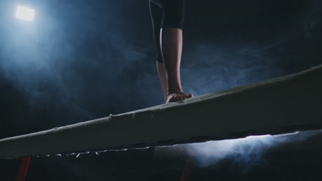 Legs-Professional-girl-gymnasts-jump-in-slow-motion-in-the-smoke-on-the-balance-beam.-Women's-Artistic-Gymnastics