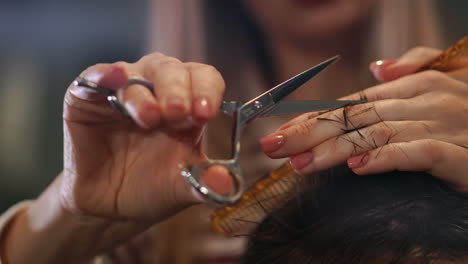 Close-up-of-men's-hair-cutting-scissors-in-a-beauty-salon.-Frame.-Close-up-of-a-haircut-at-a-hair-saloon.-Professional-barber-styling-hair-of-his-client