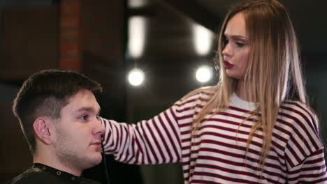 Hairdresser-cutting-male-hair-with-electric-shaver-in-beauty-school.-Woman-haircutter-making-male-haircut-with-hair-clipper-in-barbershop-close-up