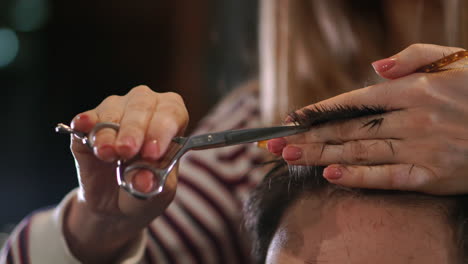 Close-up-hairdresser-with-scissors-and-comb.-Blurred-background.