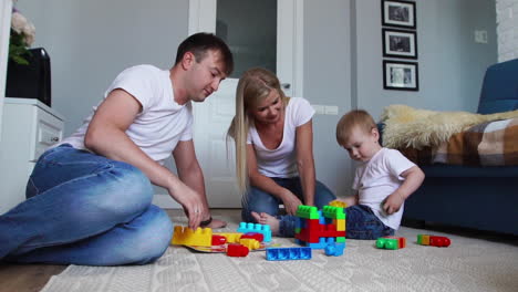 Familia-Feliz,-Papá,-Mamá-Y-Bebé-De-2-Años-Jugando-Lego-En-Su-Luminosa-Sala-De-Estar.-Familia-Feliz-Filmando-En-Cámara-Lenta