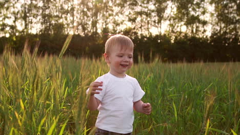 Boy-in-white-shirt-walking-in-a-field-directly-into-the-camera-and-smiling-in-a-field-of-spikes
