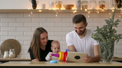 Familie-Aus-Mutter,-Vater-Und-Baby-Sitzt-Zu-Hause-Mit-Einem-Tablet-PC
