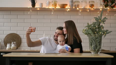 Close-up-portrait-of-a-happy-couple-taking-a-selfie-with-baby