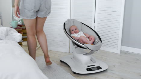 Modern-high-tech-rocking-chair-helps-parents-put-the-child-to-bed.-White-interior-of-children's-room