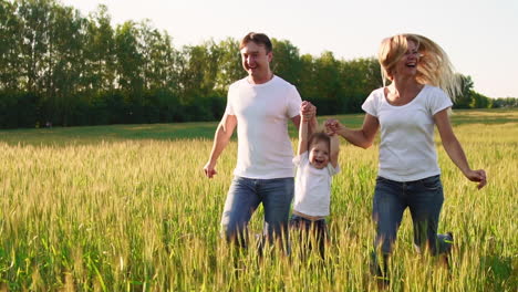 Glückliche-Familie:-Vater,-Mutter-Und-Sohn,-Die-In-Weißen-T-Shirts-Gekleidet-Auf-Dem-Feld-Laufen