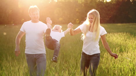 Glückliche-Familie,-Mama,-Papa-Und-Sohn-Auf-Einem-Emotionalen-Spaziergang.-Laufen-Und-Das-Leben-Genießen-Auf-Einer-Grünen-Wiese-An-Der-Frischen-Luft,-Blauem-Himmel,-Natur