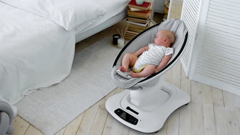 El-Bebé-Duerme-En-Una-Mecedora-Para-Niños-De-Diseño-De-Alta-Tecnología-En-Un-Dormitorio-Blanco.
