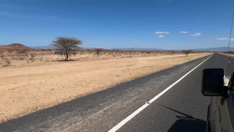 Mann-Schiebt-Ein-Fahrrad-Entlang-Einer-Leeren-Straße-In-Kenia