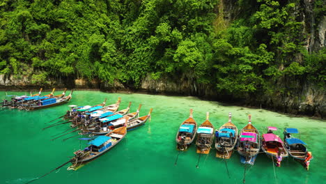 Colorful-tourist-boats-moored-in-majestic-lagoon-of-Phi-Phi-islands