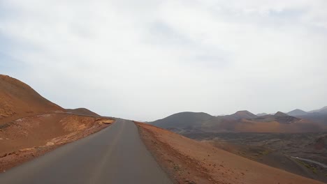timanfaya,-images-from-the-road,-volcanic-natural-park-of-Lanzarote-driving-on-the-road-point-of-view-from-the-front-of-the-car-lunar-landscape