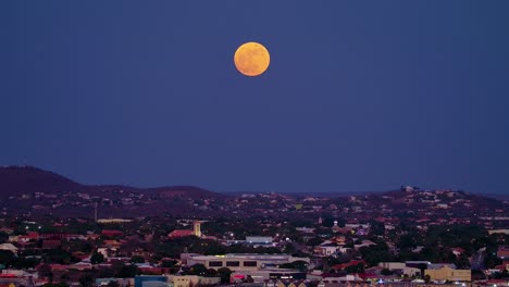 Supermoon-sits-magnificent-in-sky,-red-orange-tint-above-willemstad-curacao