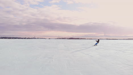 A-male-athlete-in-sports-outfit-is-doing-snow-kiting-on-beautiful-winter-landscape.