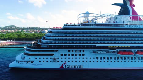 Carnival-Horizon-cruise-liner-ship-with-tourists-docks-on-local-caribbean-port-stop,-aerial-trucking-pan