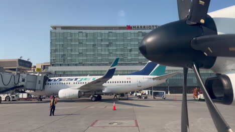WestJet-Airplane-Parking-at-Airport-Gate-Near-Other-Parked-WestJet-Airplane-at-Calgary-YYC-Airport-on-7-18-2023