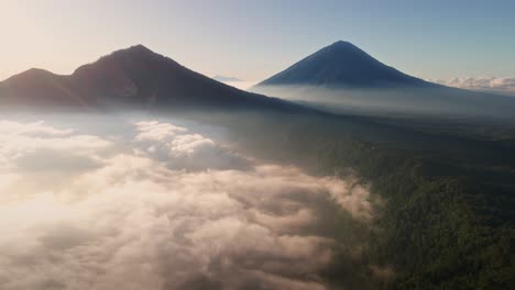 Aerial-view-around-low-hanging-clouds-with-Gunung-Batur-volcano-background,-sunny-morning-in-Bali,-Indonesia
