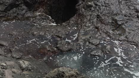 Blow-hole-filling-with-water-in-Tenerife-island,-static-view