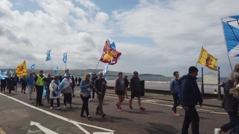 A-police-officer-walking-alongside-Pro-Scottish-Independence-marchers-in-Ayr,-Scotland