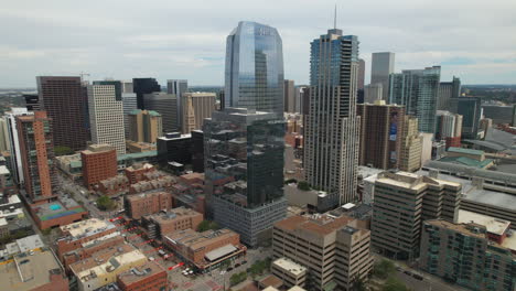 Aerial-Drone-reverse-rising-above-the-skyscrapers-of-Downtown-Denver,-Colorado,-USA