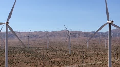 Turbines-on-a-wind-farm-generate-sustainable-electricity-in-California's-Mojave-Desert---sliding-aerial
