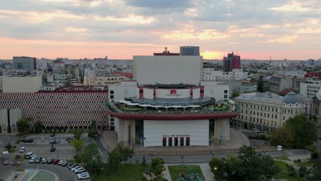 Vista-Aérea-Giratoria-Del-Teatro-Nacional-De-Bucarest,-Rumania,-Puesta-De-Sol
