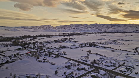 Oakley-Utah-Aerial-v4-drone-flyover-and-around-the-town-area-capturing-the-serene-beauty-of-snow-covered-fields,-a-majestic-mountainscape-and-winter-sunset---Shot-with-Mavic-3-Cine---February-2023