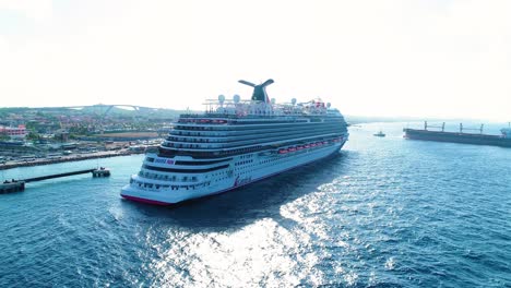 Carnival-horizon-cruise-liner-exits-port-harbor,-aerial-pedestal-establishing-of-ship-in-ocean