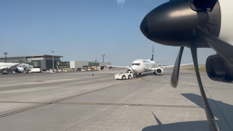 Avión-Pasando-Por-El-Avión-Westjet-Estacionado-En-La-Pista-Del-Aeropuerto-De-Calgary-YYC-El-18/7/2023