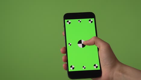 Woman-swipes-up-and-down-on-phone-in-front-of-green-screen