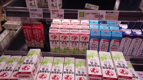 Japanese-supermarket-selection-of-dairy-milk-carton-products,-slide-to-left-displaying-packaging-in-conbini-convenience-store