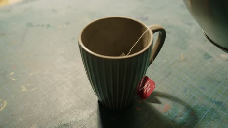 Teabag-being-covered-with-hot-water-in-a-cup