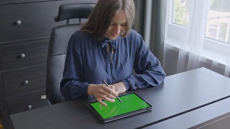 Lächelnde-Frau-Am-Schreibtisch,-Skizzieren-Mit-Digitalstift-Auf-Grünem-Tablet-Bildschirm