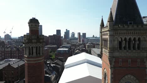 Aerial-drone-flight-between-the-two-towers-of-Manchester-Crown-Court-with-a-skyline-view-of-Manchester-skyscrapers