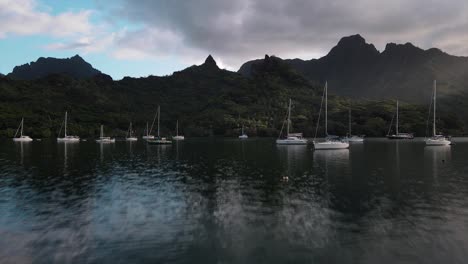 many-sailing-yachts-anchored-in-the-sheltered-bay-of-Moorea-island-in-French-Polynesia-with-spectacular-lush-tropical-mountains