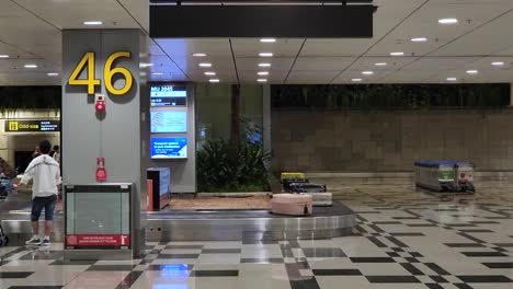 Passenger-Waiting-To-Collect-Its-Luggage-At-The-Baggage-Reclaim-Area-At-Terminal-3-Of-Changi-Airport,-Singapore