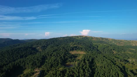 Forstwirtschaft-Der-Bergkette-Auf-Grüner-Decke-Unter-Blauem-Himmel,-Wunderschöner-Naturhintergrund-Auf-Schwenk-über-Dem-Dorf-Voskopoja-In-Albanien