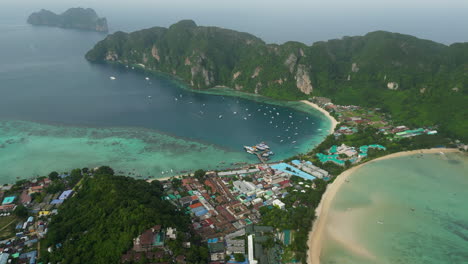 Tropical-rainstorm-flowing-over-Koh-township-and-Phi-Phi-islands,-aerial-view