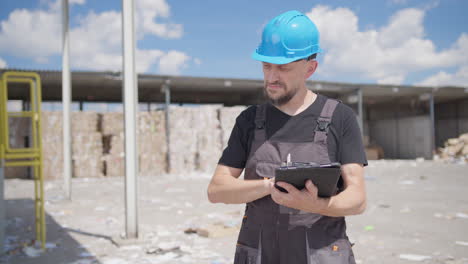Mittlere-Aufnahme-Eines-Männlichen-Kaukasischen-Arbeiters-In-Einer-Recyclinganlage-Mit-Tablet